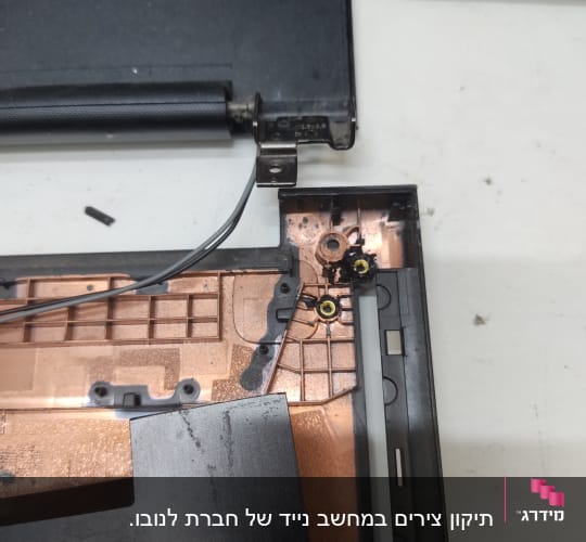 חלקי מחשב נייד פתוחים עם צירים וחוטים גלויים